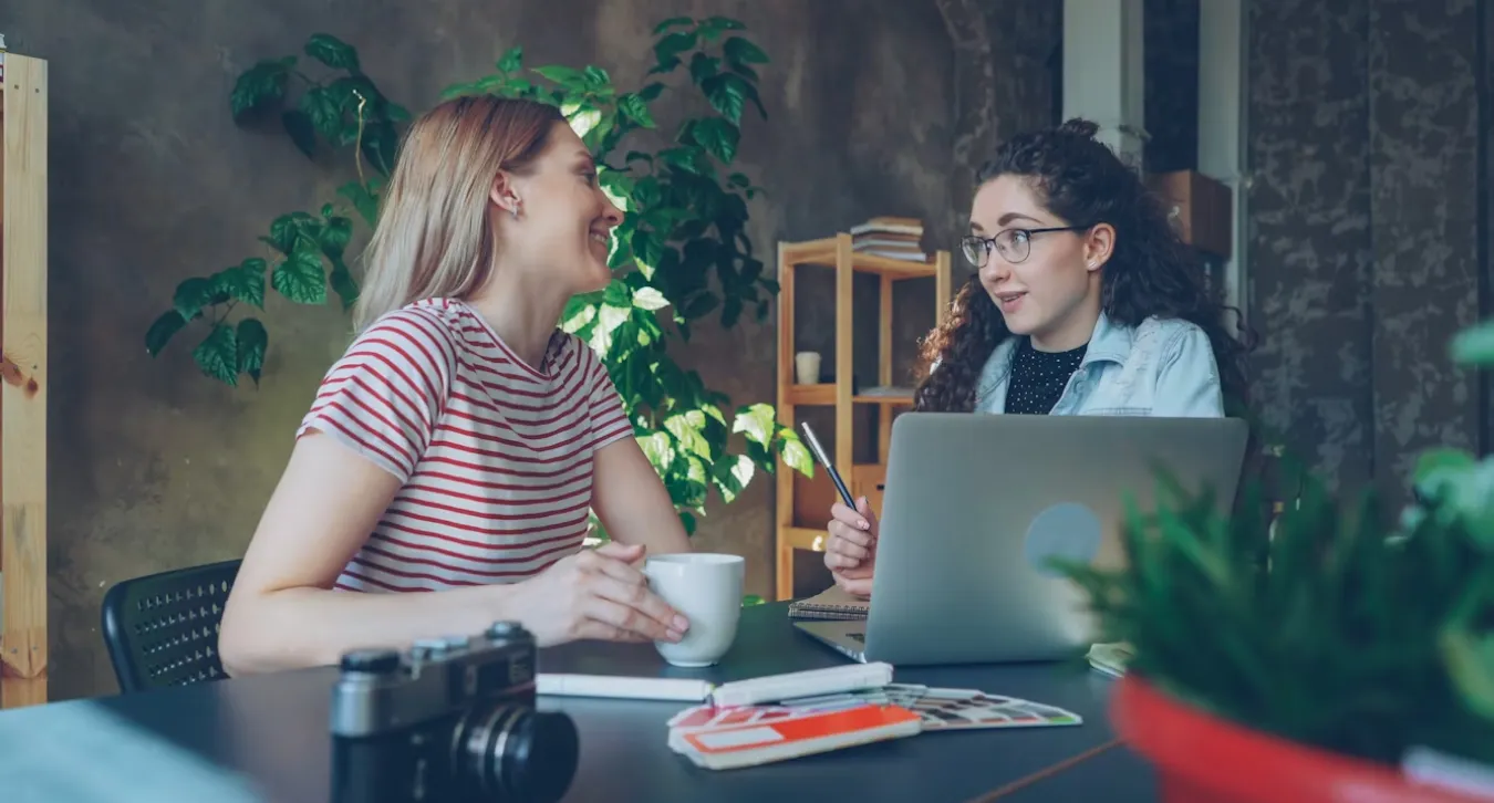 Two women talking together about a project