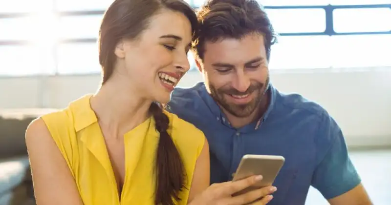 man and women checking phone together