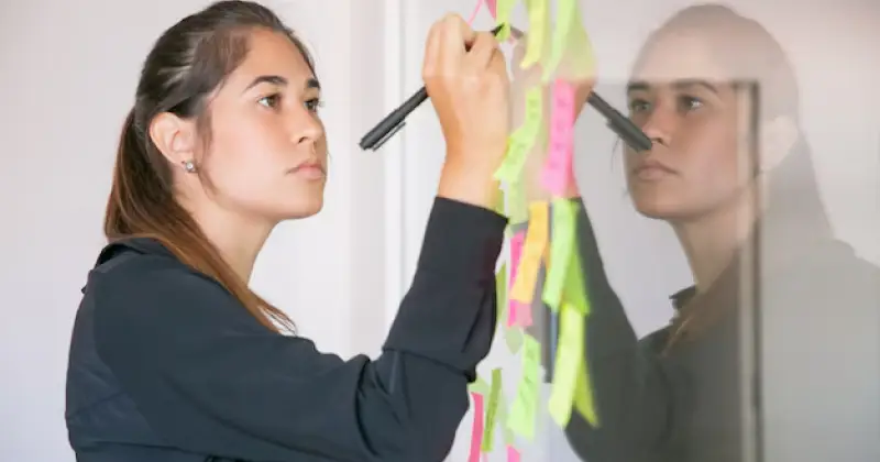 an employee writing on work board