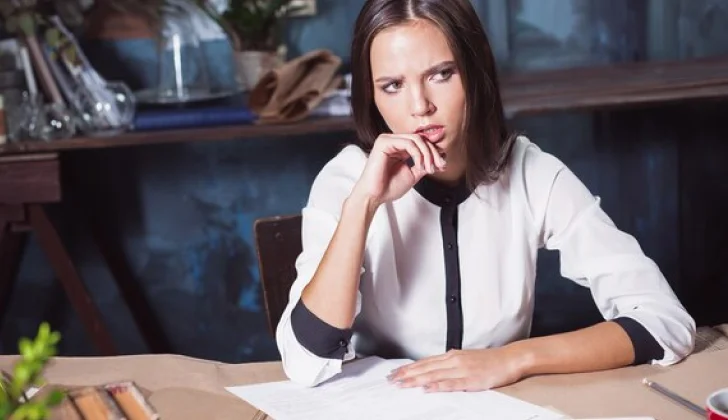 a woman writing and looking worried