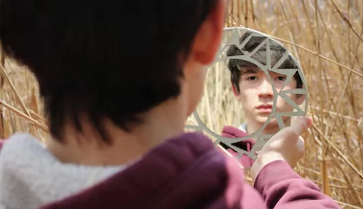 a guy looking at himself in a mirror