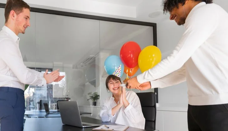 employees welcoming a new team member with a cake