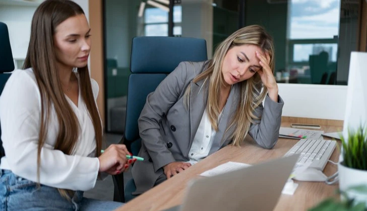 two employees discussing a project at work