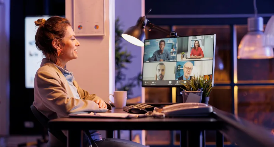 a woman sitting in an office, having a virtual meeting