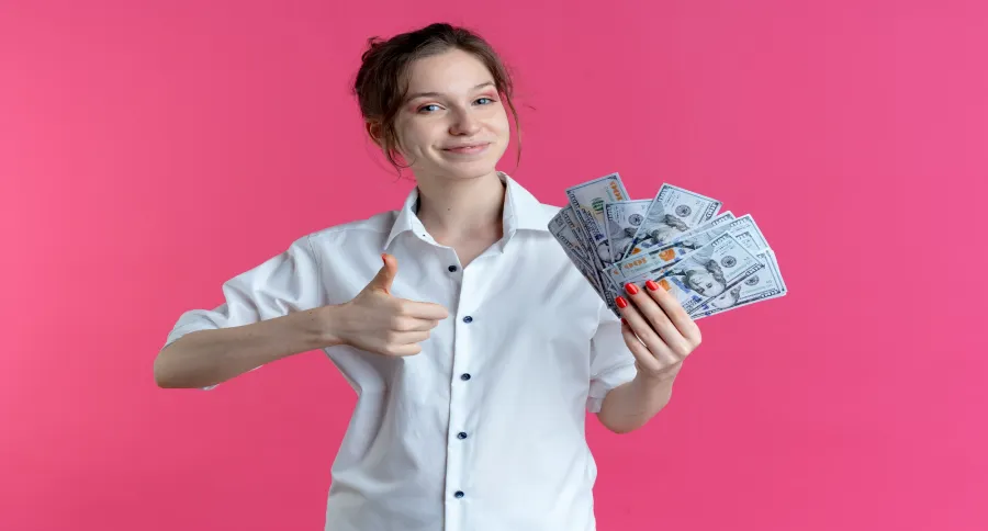 A woman holding money with a thumbs up