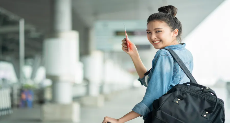 a woman holding a flight ticket in an airport
