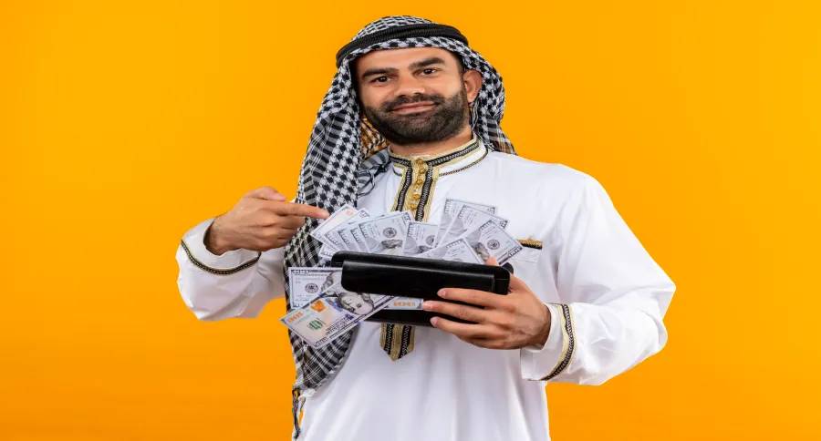 a man in traditional clothing holding a wallet full of money